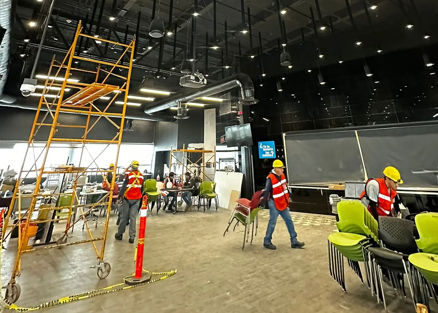 Comedor corporativo durante la instalación de elementos acústicos suspendidos.